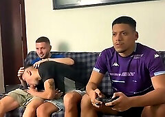 Well-endowed men fucking a naughty twink playing video games.